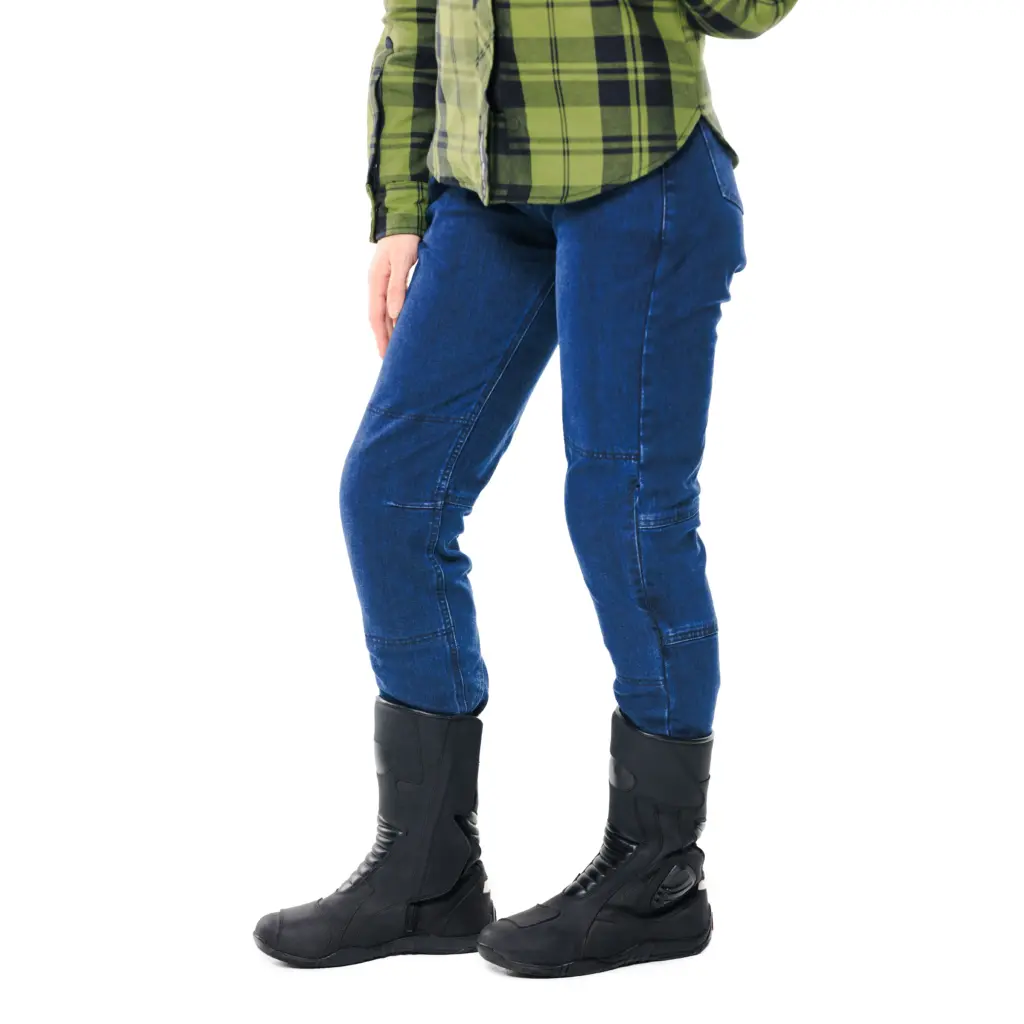 Alfa Thrust Ember Ace – jeansy motocyklowe damskie, niebieskie spodnie z wysokimi butami i koszulą w kratę na białym tle