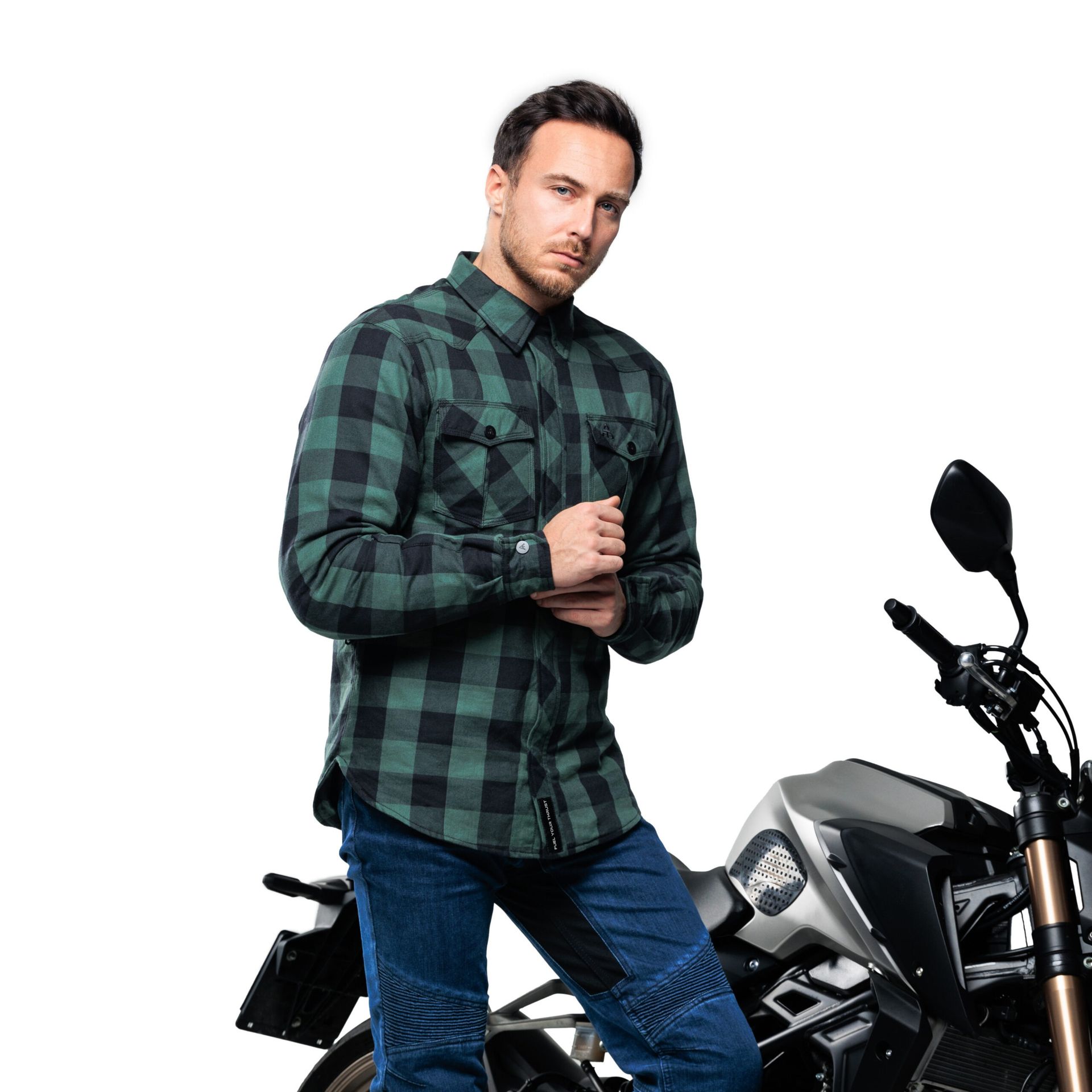 Alfa Thrust Casper Steel Red – koszula motocyklowa, mężczyzna w zielonej koszuli w kratę stojący przy motocyklu.