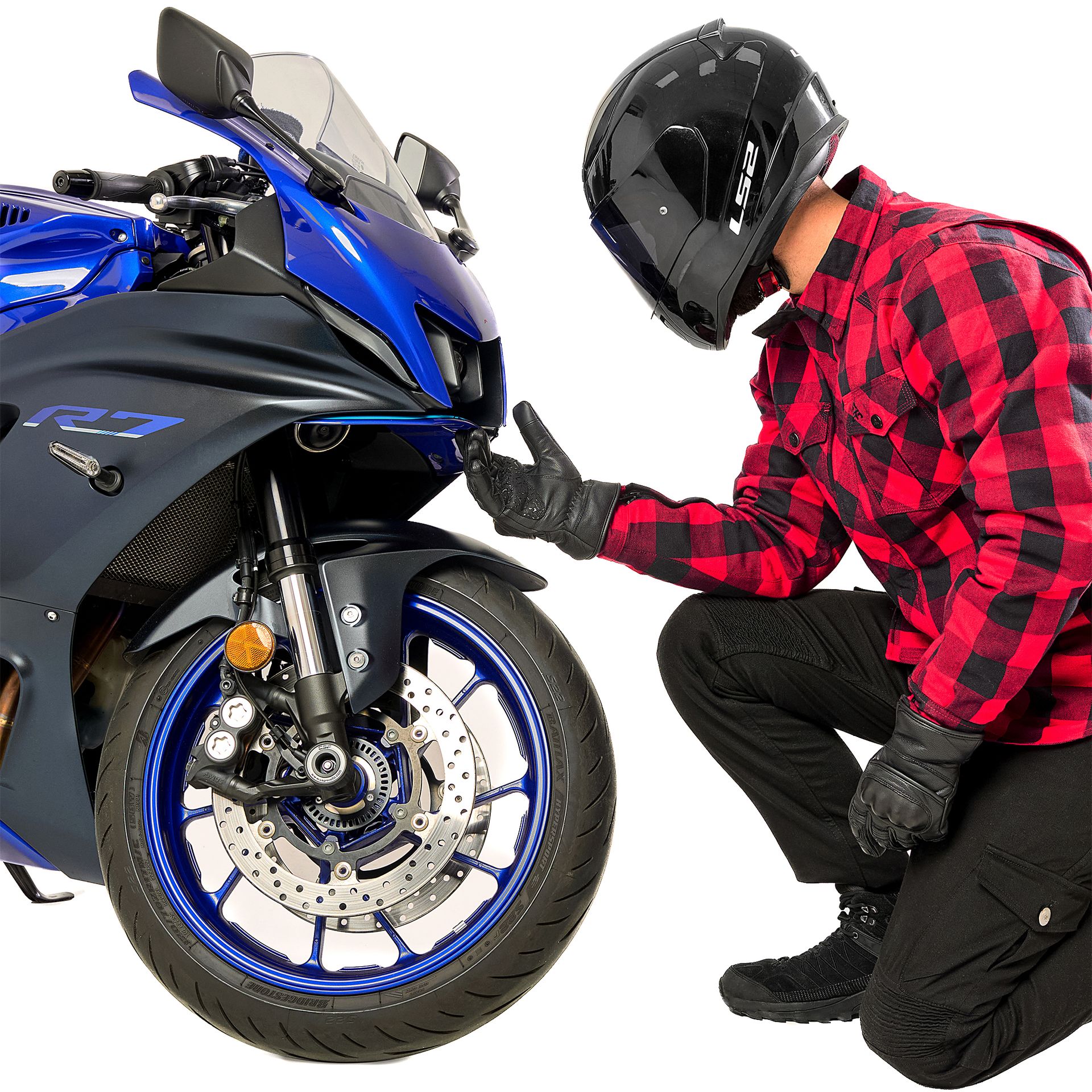 Alfa Thrust Casper Steel Red – koszula motocyklowa, motocyklista w czerwonej flaneli klęczący przy niebieskim motocyklu.