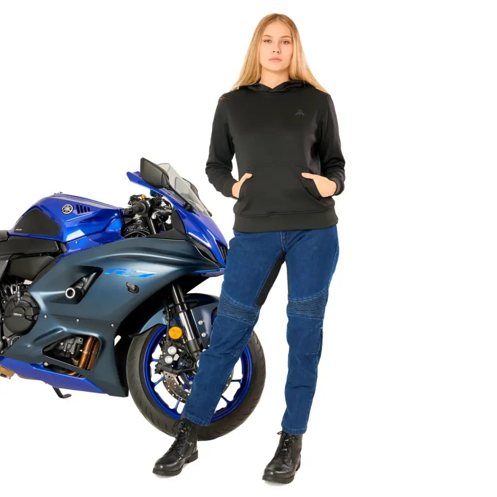 Alfa Thrust Ivy Burn – bluza motocyklowa damska, czarna bluza z kapturem i jeansy przy niebieskim motocyklu sportowym.