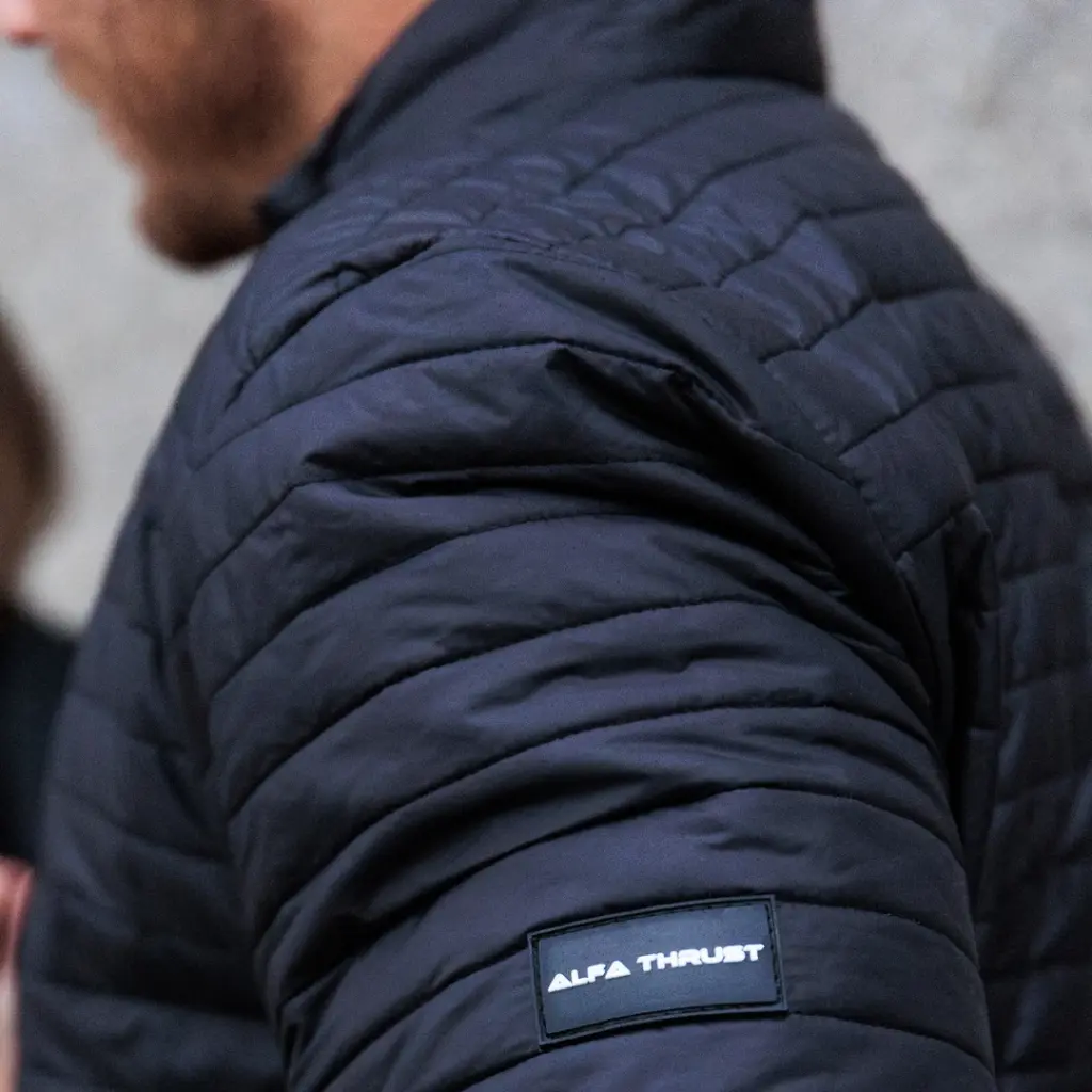 Patric Wolf Winter Jacket – kurtka motocyklowa, zbliżenie na czarny materiał i logo na rękawie.